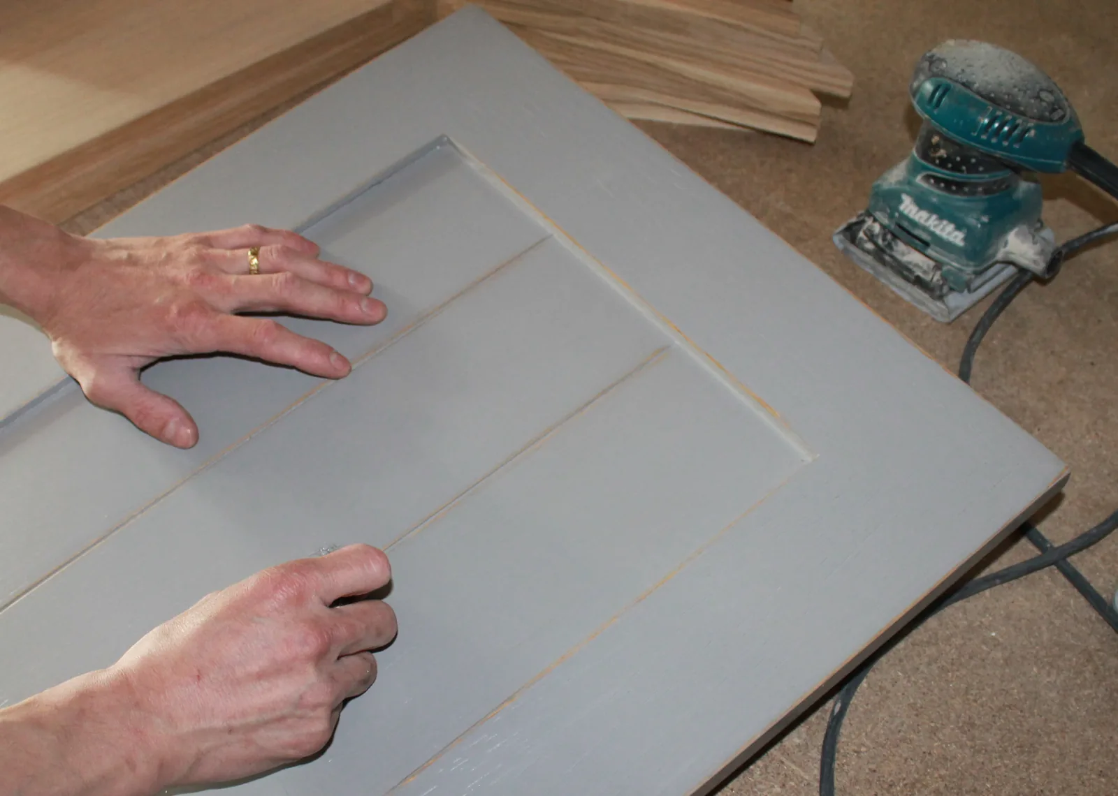 Travail de finition sur un meuble, illustrant le savoir-faire artisanal