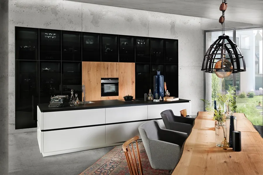 Parfaite alliance de vitrines noires, armoires et table bois pour une cuisine moderne et fonctionnelle