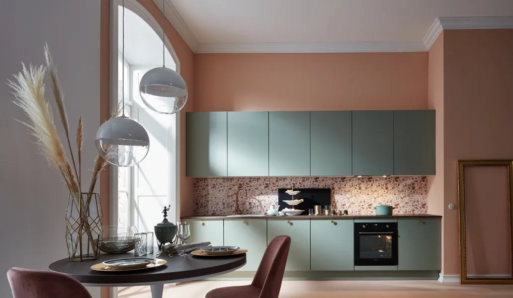 Bonne humeur assurée avec cette cuisine qui associe avec brio, meubles verts, boutons dorés et crédence terrazzo