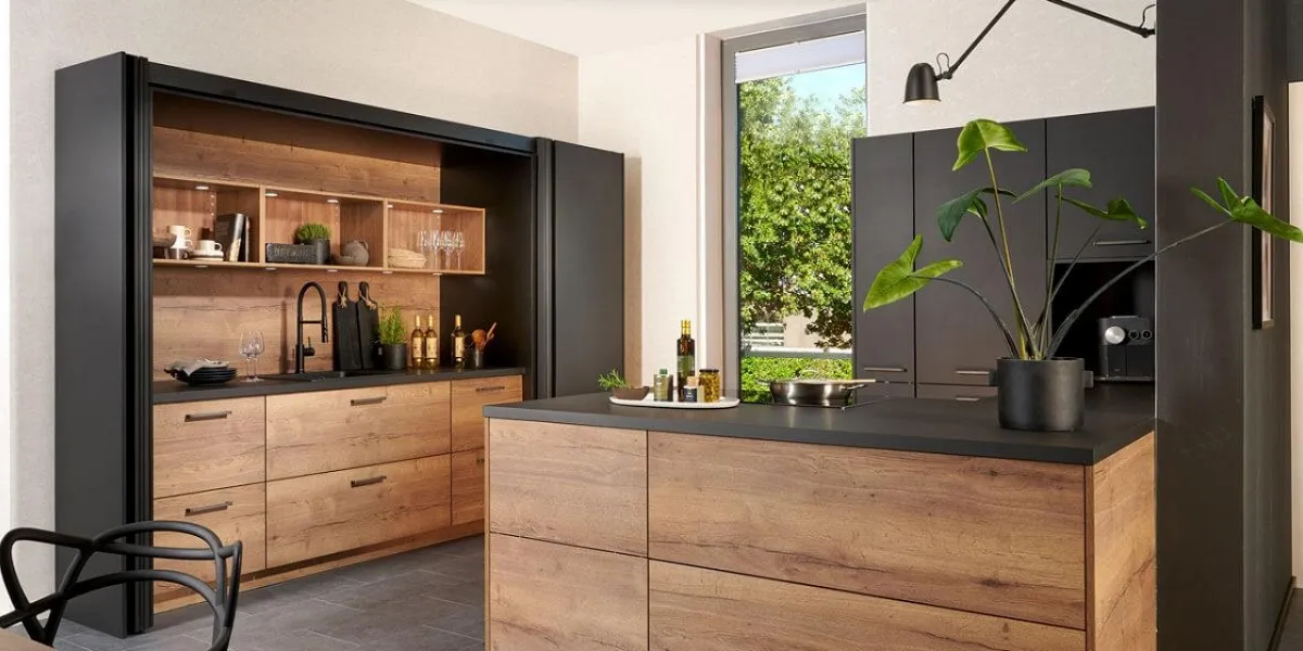 Cuisine moderne chaleureuse et astucieuse de par ses grandes portes noires pouvant, quand on le souhaite, dissimuler le espace évier