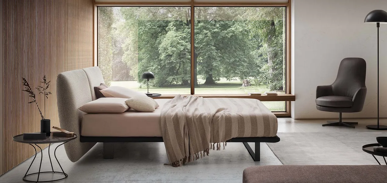 Lit design et aérien avec tête de lit coussins en tissu beige, pieds métal et sommier fin à lattes. Disponible en + 400 tissus et cuirs