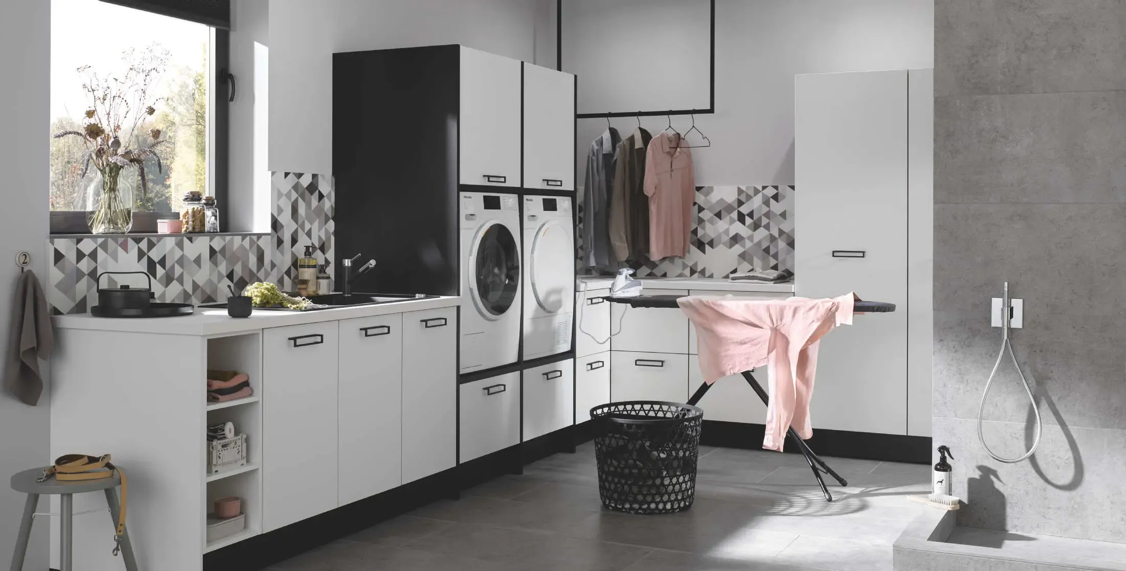 Noir et blanc  pour cette grande buanderie aménagée avec lave-linge et sèche-linge en hauteur