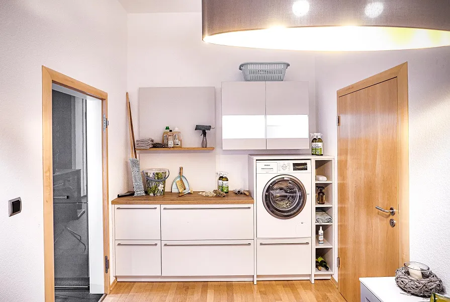 Pièce tampon entre la cuisine et le garage, ce cellier a également son petit coin buanderie aménagé avec de grands tiroirs coulissants